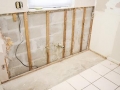 Interior of kitchen with drywall torn out because of water damage and the resulting mold.