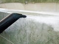 thick stream of fog on a tile wall, cleaning machine nosle
